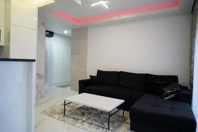 a living room with a black couch and a table at Villa Vidovic Banja Luka in Banja Luka