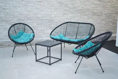 three chairs and a table in front of a brick wall at Villa Vidovic Banja Luka in Banja Luka