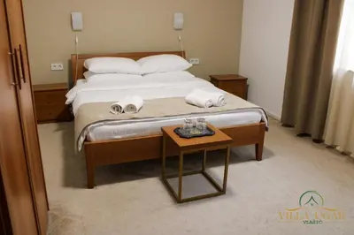 a bedroom with a bed with towels and a table at Hotel Villa Ugar Vlašić in Vlasic
