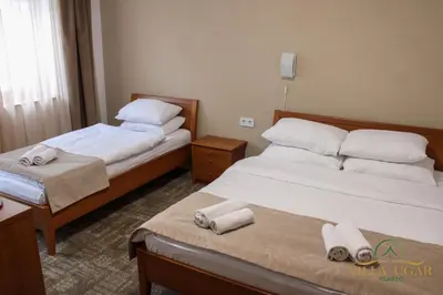 two beds in a hotel room with towels on them at Hotel Villa Ugar Vlašić in Vlasic