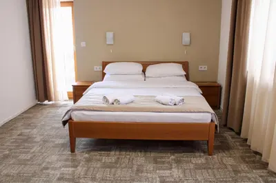 a bedroom with a bed with two stuffed animals on it at Hotel Villa Ugar Vlašić in Vlasic