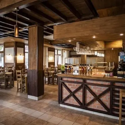 a restaurant with a bar in the middle of a room at Hotel Villa Ugar Vlašić in Vlasic