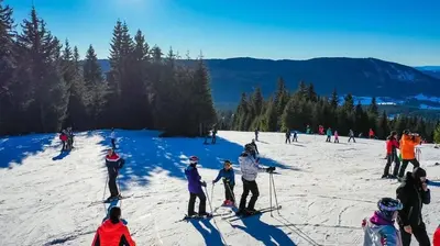 a group of people skiing on a snow covered slope at Hotel Villa Ugar Vlašić in Vlasic