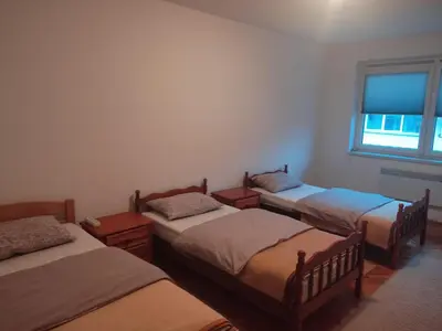 a room with three beds and a window at Apartman Laura in Kupres