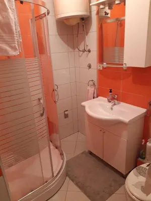 a bathroom with a shower and a sink and a toilet at Apartman Laura in Kupres
