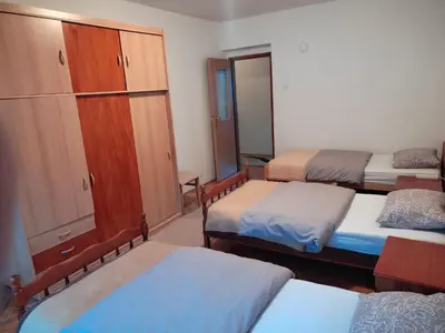 a room with three beds and a cupboard at Apartman Laura in Kupres