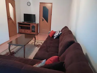 a living room with a brown couch and a table at Apartman Laura in Kupres