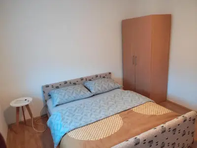 a bedroom with a bed with a wooden cabinet at Apartman Laura in Kupres