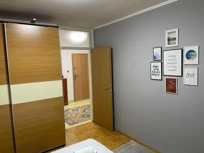a room with a wooden door and a hallway at Apartment Host in Tuzla