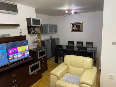 a living room with a couch and a television at Apartment Host in Tuzla