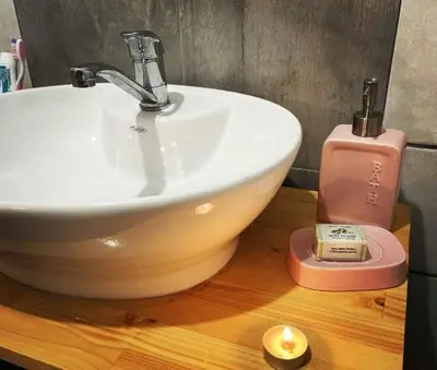 a bathroom with a sink and a candle on a counter at Bajka na dan two bedroom apartment in Bosanska Gradiška