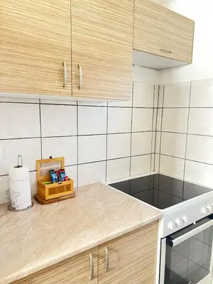 a kitchen with wooden cabinets and a counter top at Bajka na dan two bedroom apartment in Bosanska Gradiška