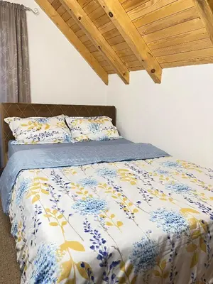 a bed with a blue and yellow comforter at Bajka na dan two bedroom apartment in Bosanska Gradiška
