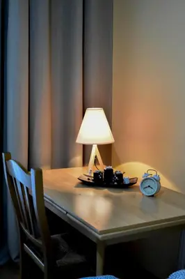 a table with a lamp and an alarm clock on it at Apartment Studenac in Banja Luka