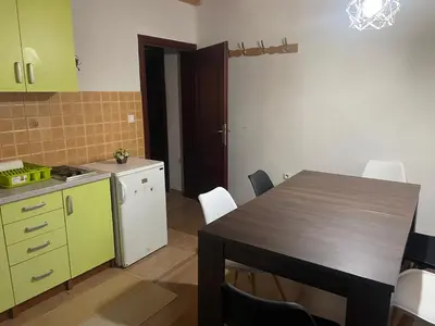 a kitchen with a table and a kitchen with green cabinets at Sandy Vlašić in Vlasic