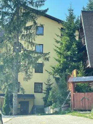 a yellow building with trees in front of it at Sandy Vlašić in Vlasic