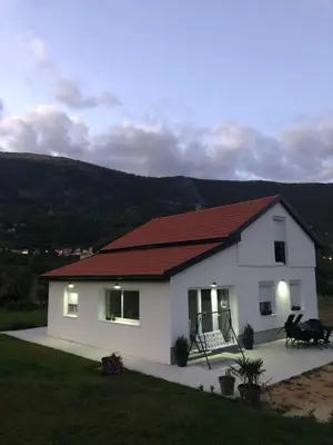 a small white house with a red roof at Vikendica Bruše in Jaklići
