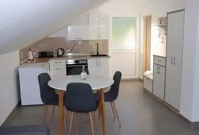 a kitchen with a white table and chairs in it at Vikendica Bruše in Jaklići