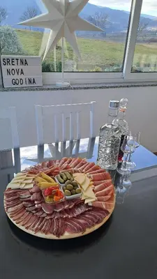 a plate of meats and cheese on a table at Vikendica Bruše in Jaklići