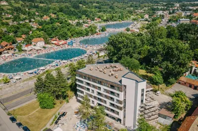 an aerial view of a hotel and a river at Muki Park Lake in Tuzla