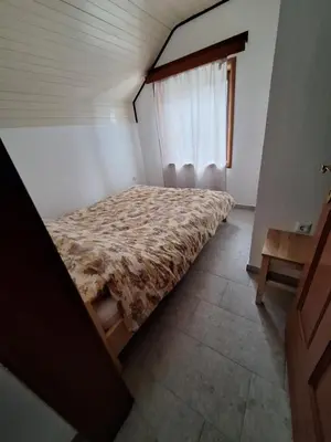 a bedroom with a bed in a room with a window at Apartmani 