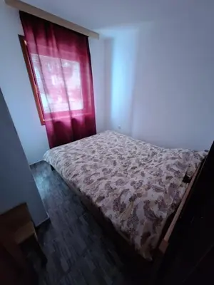 a bed in a room with a red window at Apartmani 