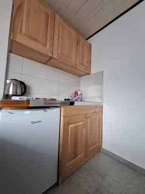 a kitchen with a white refrigerator and wooden cabinets at Apartmani 