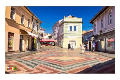 a city street with people walking on a mosaic floor at Park Lake Suite in Tuzla