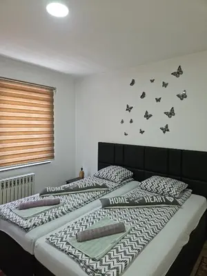 two beds in a bedroom with bats on the wall at Apartments Arna in Visoko