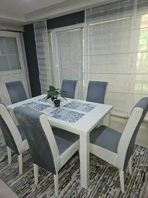 a dining room table with chairs and a white table at Apartments Arna in Visoko