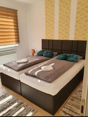 a large bed with blue pillows in a room at Apartments Arna in Visoko