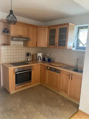 a kitchen with wooden cabinets and a sink at Kuća za odmor Ivana in Kupres