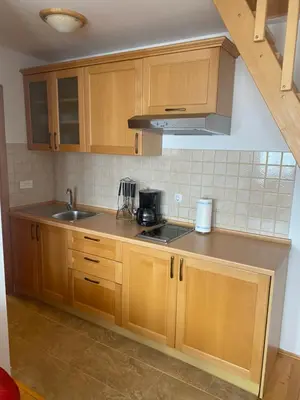 a kitchen with wooden cabinets and a sink at Kuća za odmor Ivana in Kupres