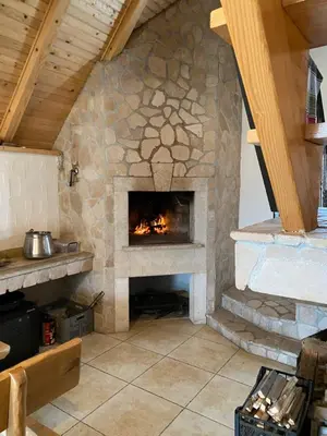a stone fireplace in a living room with at Kuća za odmor Ivana in Kupres