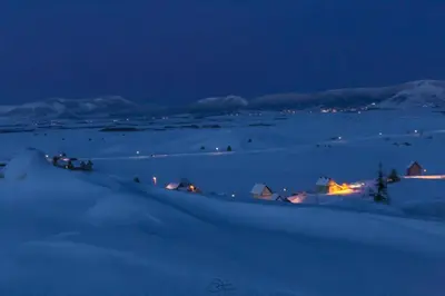 a night view of a snowy field with a town at Kuća za odmor Ivana in Kupres