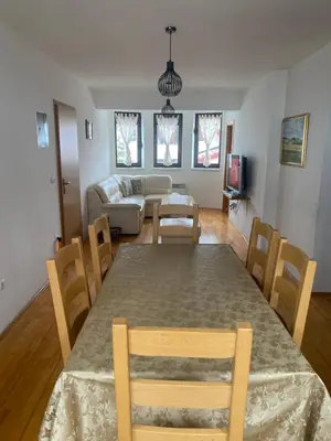 a dining room and living room with a table and chairs at Kuća za odmor Ivana in Kupres