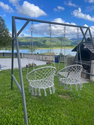 two swings in the grass with a view of a lake at Vikendica Bošnjak in Prozor