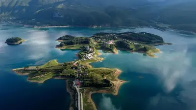 an island in the middle of a body of water at Vikendica Bošnjak in Prozor