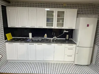 a kitchen with white cabinets and a sink and a refrigerator at Apartman House Jasmina in Bihać