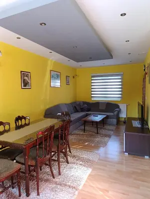 a living room with a couch and a table and chairs at Apartman Ivano in Kupres