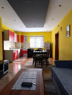 a living room with a table and a kitchen at Apartman Ivano in Kupres