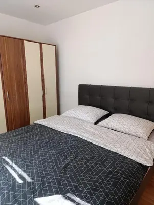 a bed with a black headboard in a bedroom at Apartman Ivano in Kupres