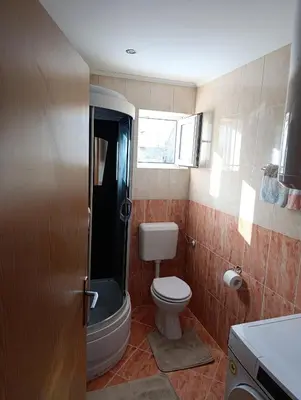 a small bathroom with a toilet and a shower at Apartman Ivano in Kupres