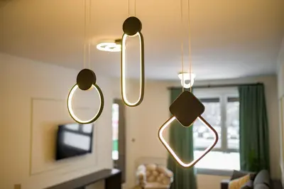 a living room with three lights hanging from the ceiling at Apartman EpiLux in Tuzla