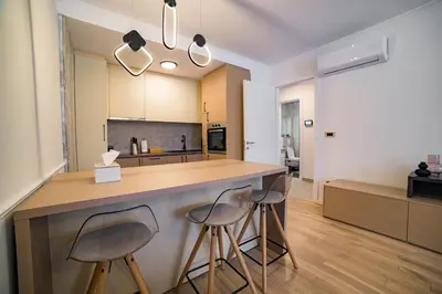 a kitchen with two stools at a counter in a kitchen at Apartman EpiLux in Tuzla