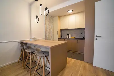 a kitchen with a island and bar stools at Apartman EpiLux in Tuzla