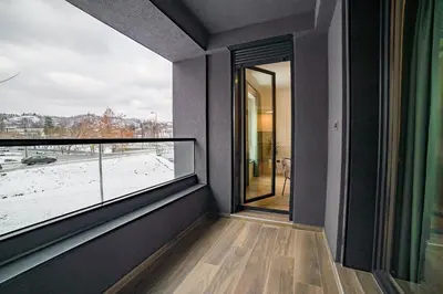 a room with a balcony with a large window at Apartman EpiLux in Tuzla