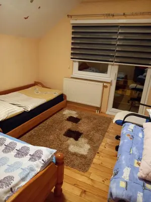 a small bedroom with two beds and a window at Apartman Suzana in Kupres
