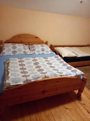 a bed with a blue and white quilt on it at Apartman Suzana in Kupres