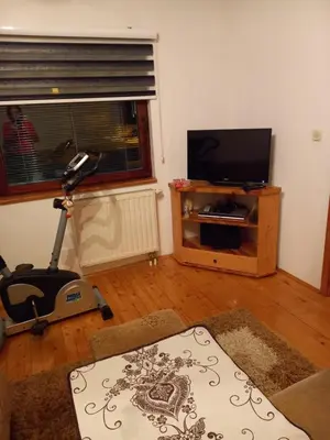 a living room with a television and a vacuum at Apartman Suzana in Kupres